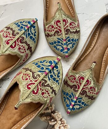 Biba Jutti with Phirozy and Magenta velvet inserts and hand embroidered with Golden tilla (Zari). A stunning blend of tradition and comfort. Lovingly handcrafted by skilled artisans, this Punjabi jutti, also known as mojari or Delhi fashion jutti